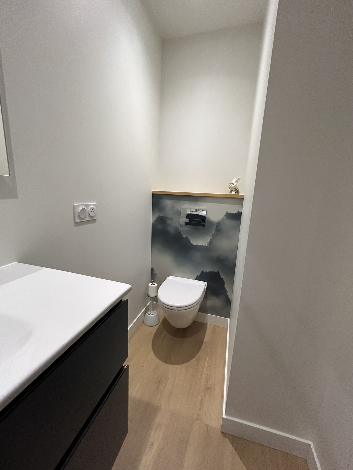 WC suspendu avec papier peint paysage