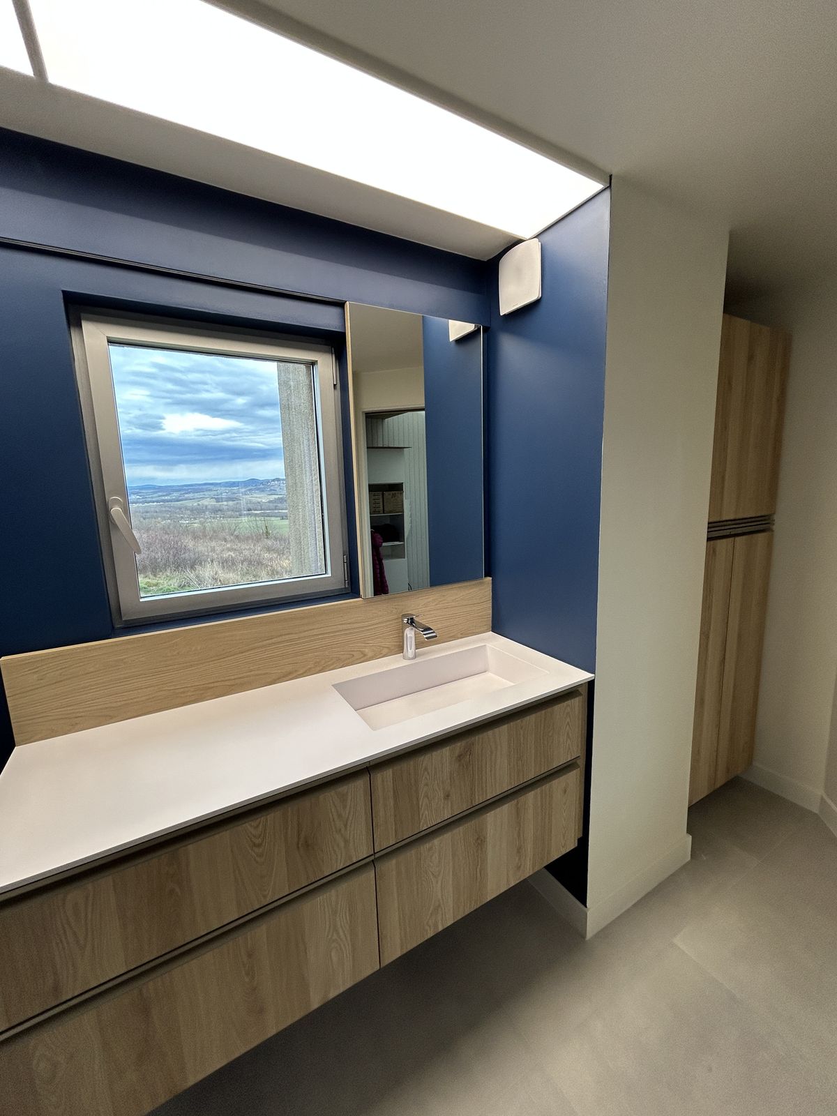 Salle de bain bleu nuit avec meuble bois
